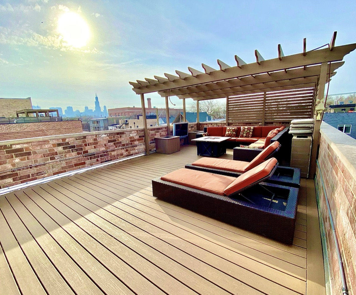 Rooftop deck with pergola and Chicago skyline at golden hour